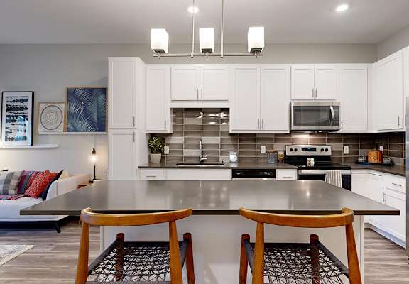 A modern kitchen with a large island and stainless steel appliances.