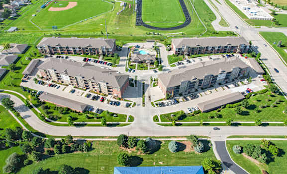 arial view of The Flats at 84 with green grass and a track in the background