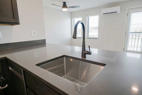 A stainless steel drop-in sink with a gooseneck faucet