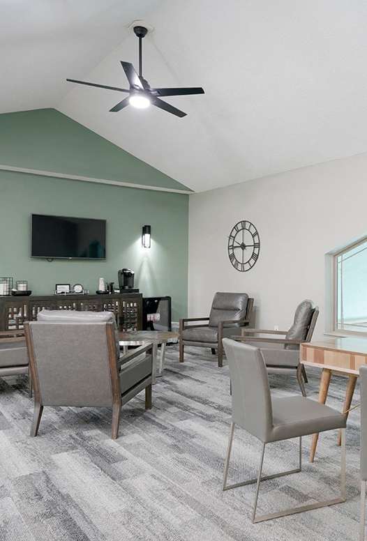 A living room with a grey sofa, a coffee table, and a mirror.