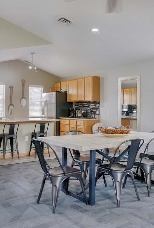 clubhouse with dark gray sectional, tall ceilings, and kitchen
