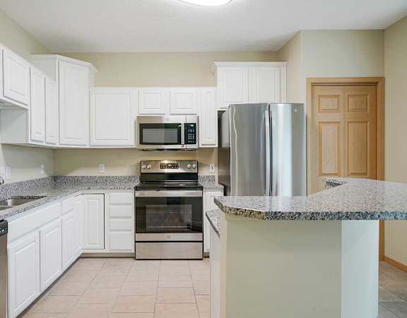 a kitchen with white cabinets and stainless steel appliances