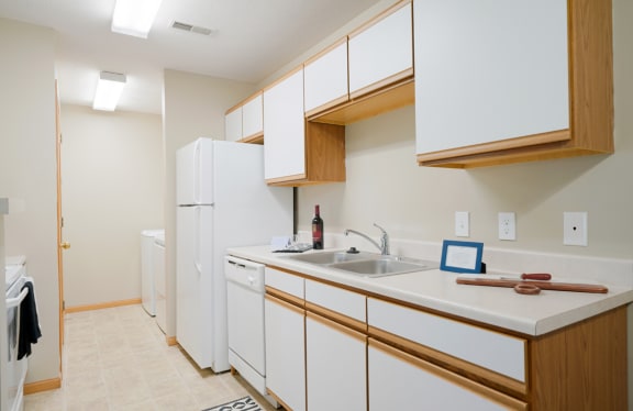 a kitchen with white cabinets and a sink and a refrigerator