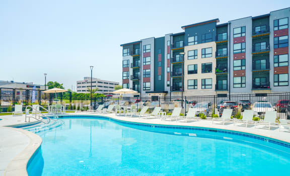 a swimming pool with the Haven at Uptown apartments in the background