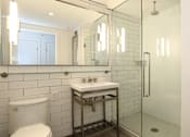 Thumbnail 11 of 23 - A white toilet sits next to a sink in a bathroom.