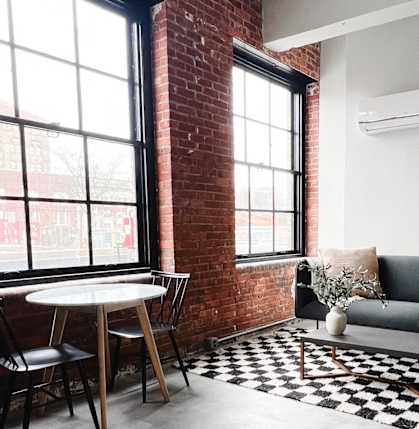 a living room with a couch and a table and a brick wall