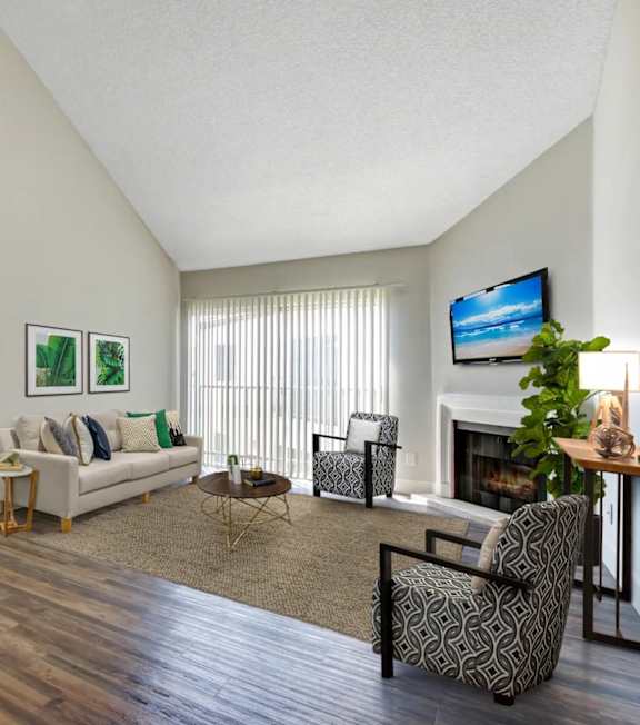 A living room with a fireplace, a couch, a chair, and a television.