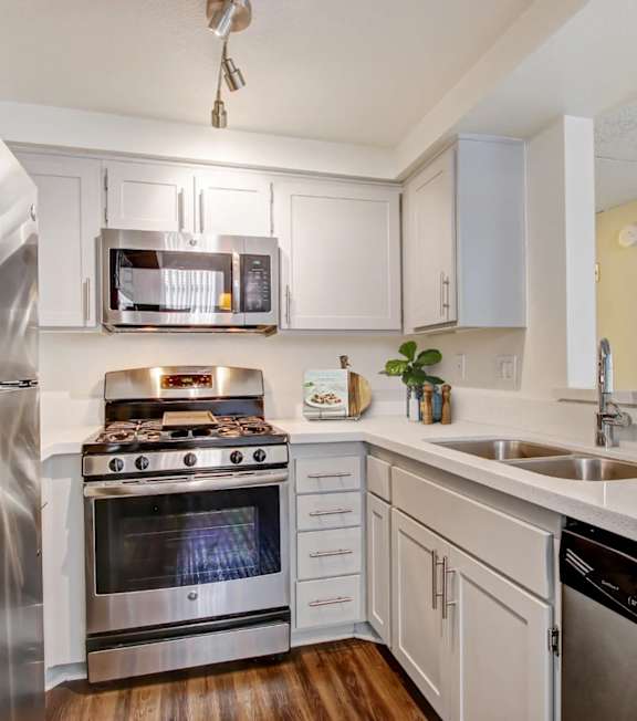 A modern kitchen with a stainless steel oven and white cabinets.