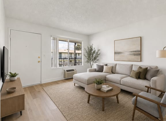 A living room with a couch, a chair, a coffee table, and a television.