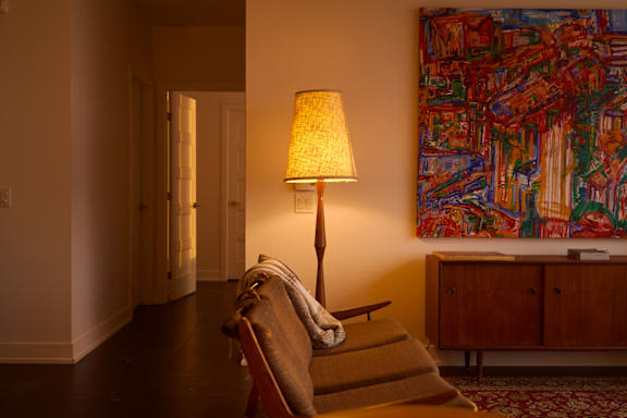 A modern living room with a large sectional sofa and a green armchair. at Le Columbia Apartments , Quebec