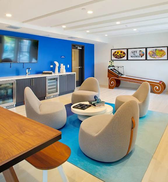 A modern living room with a wooden table and grey armchairs.