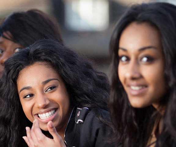 two women are looking at the camera and smiling