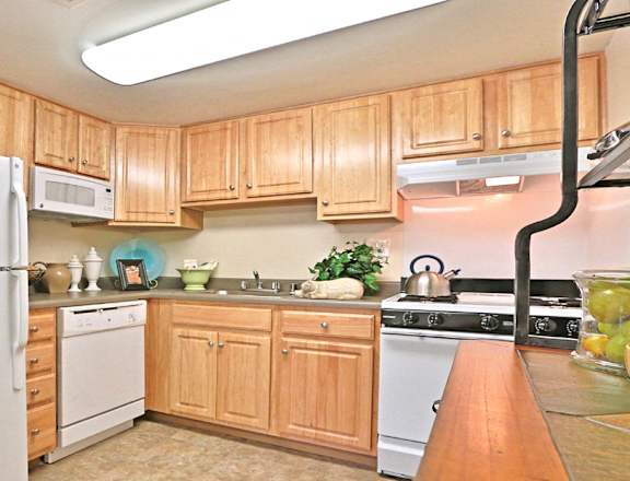 a kitchen with white appliances and wooden cabinets