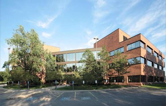A large building with a parking lot in front of it.