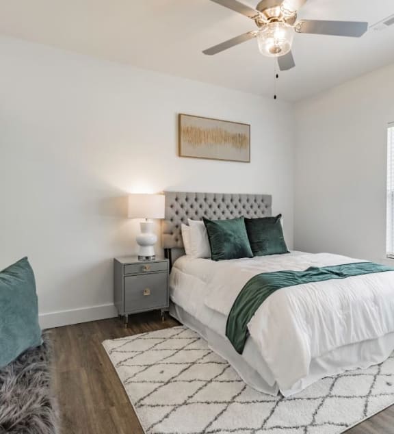 a bedroom with a bed and a ceiling fan