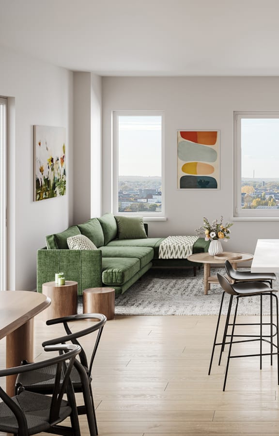 A modern kitchen with white appliances and a green couch.