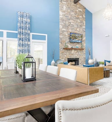 A dining room with a wooden table and white chairs.