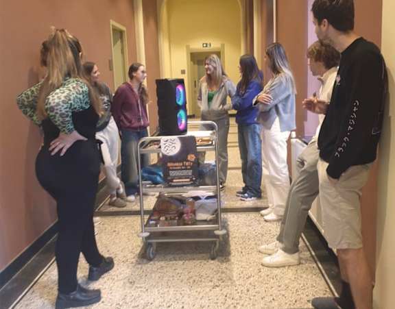 A group of people are standing in a line in a hallway.