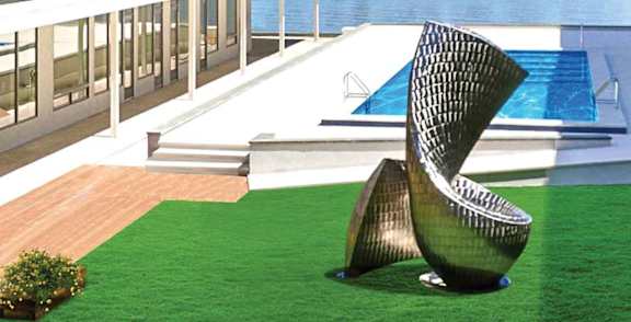 A modern chair is placed on a green lawn.