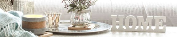 a table with a vase of flowers and a candle on it