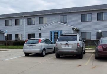a parking lot with three cars in front of a building