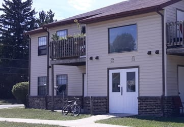 a house with two balconies and a bicycle in the front yard