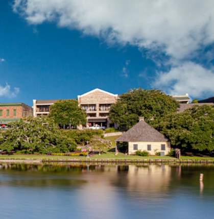 A large building sits on the shore of a lake.