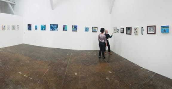 people looking at artwork in an exhibition