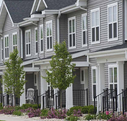 A row of houses with trees in front.