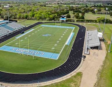 A blue and white track and field stadium with the word "SPORTS" written on the field.