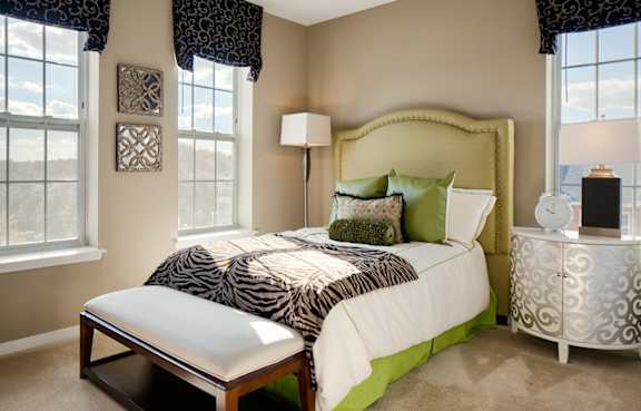 A bedroom with a zebra print bedspread and a green headboard.