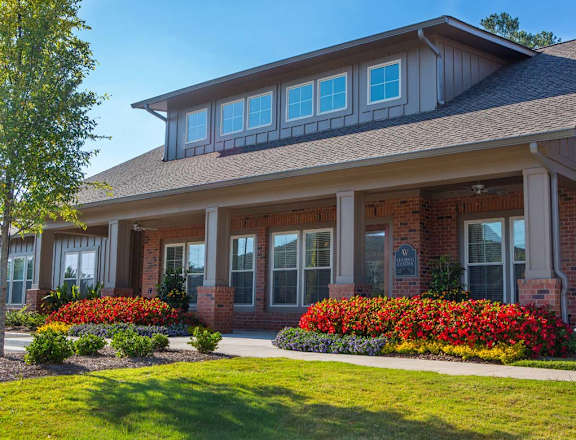 A house with a grey roof and a red brick wall.