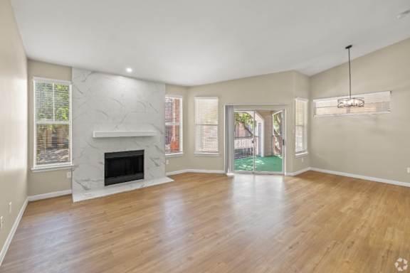 A spacious living room with a fireplace and hardwood floors.