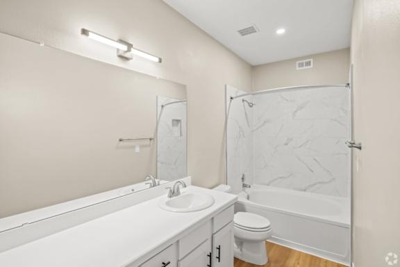 A white bathroom with a marble shower.