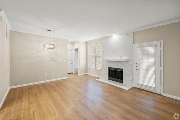 A spacious room with a fireplace and wooden floors.