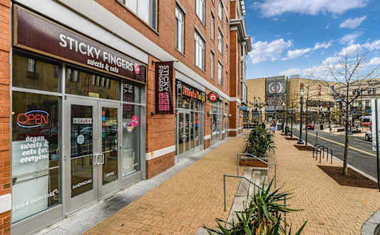 a city street with a brick sidewalk in front of a store at The Argonne Apartments, Washington, DC, 20009