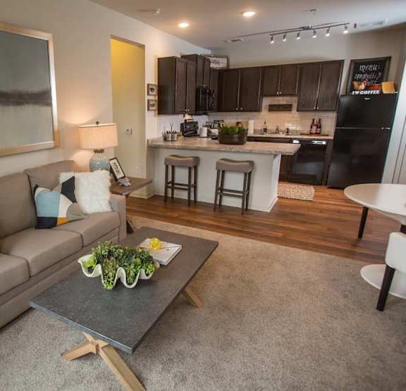 A modern living room with a grey couch and a grey coffee table.