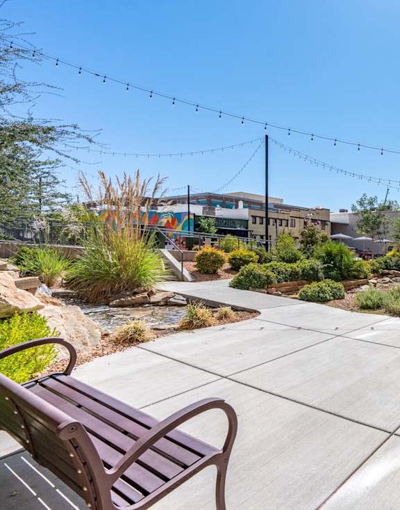 a patio with tables and umbrellas in front of an apartment building at City View St. George, St. George, 84770