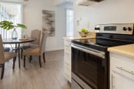 A modern kitchen with a dining table and chairs. at Three Crown Apartments, California, 94501