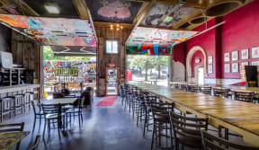 the interior of a restaurant with a long bar and tables