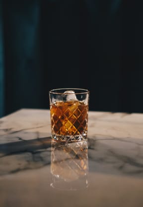 Glass of Whiskey Sitting on Table
