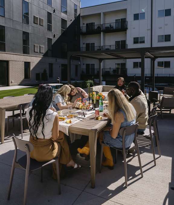 A group of people are sitting around a table eating food.
