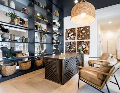 a living room with a couch and a chair and a desk