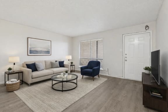 A living room with a couch, chair, and television.