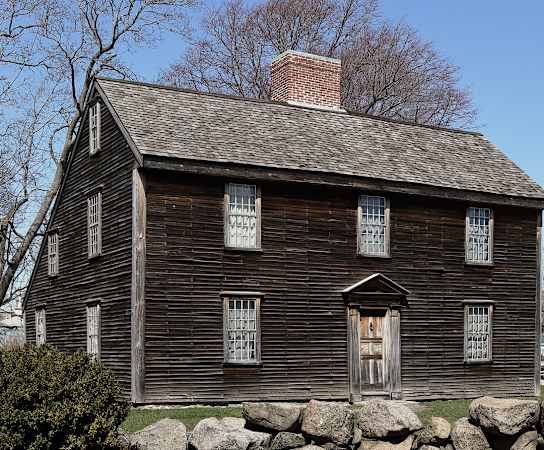 an old wooden house with a brick chimney at Highlands at Faxon Woods, Quincy, MA