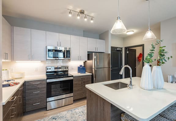 A modern kitchen with wooden cabinets and stainless steel appliances.