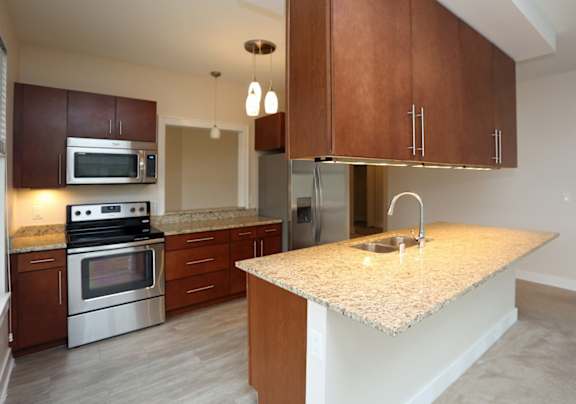 A kitchen with a granite countertop and stainless steel appliances.
