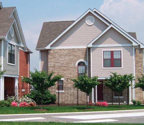 A house with a red door and a brick wall.