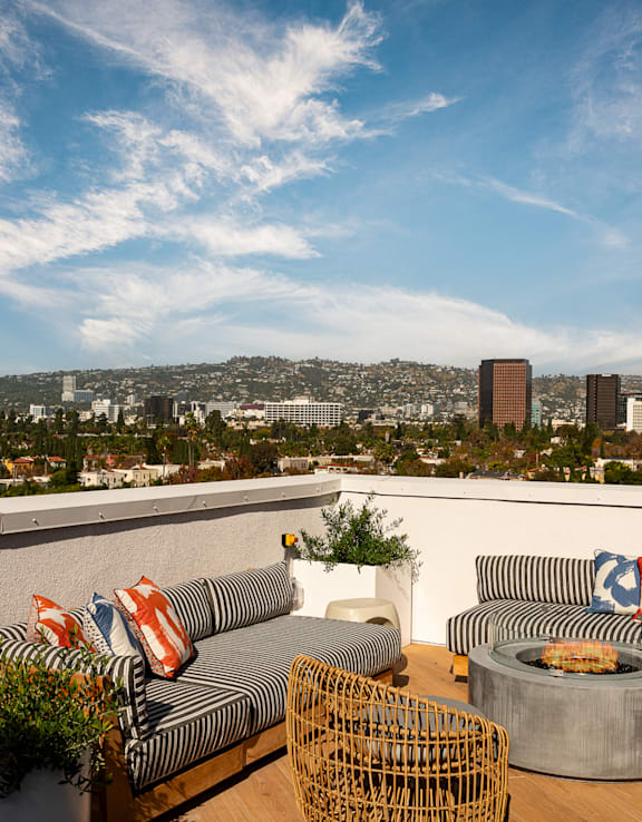 A table with two plates of food on it with a view of a city in the background.