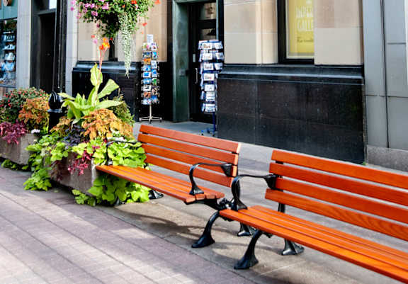 A brown bench is in front of a building with a sign that says "Stanley".